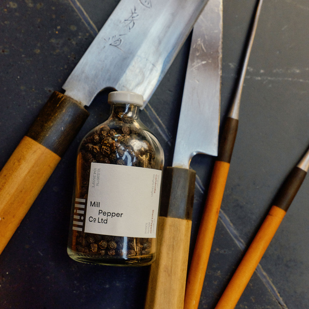 Mill Pepper Co. shot in the kitchen behind knifes.