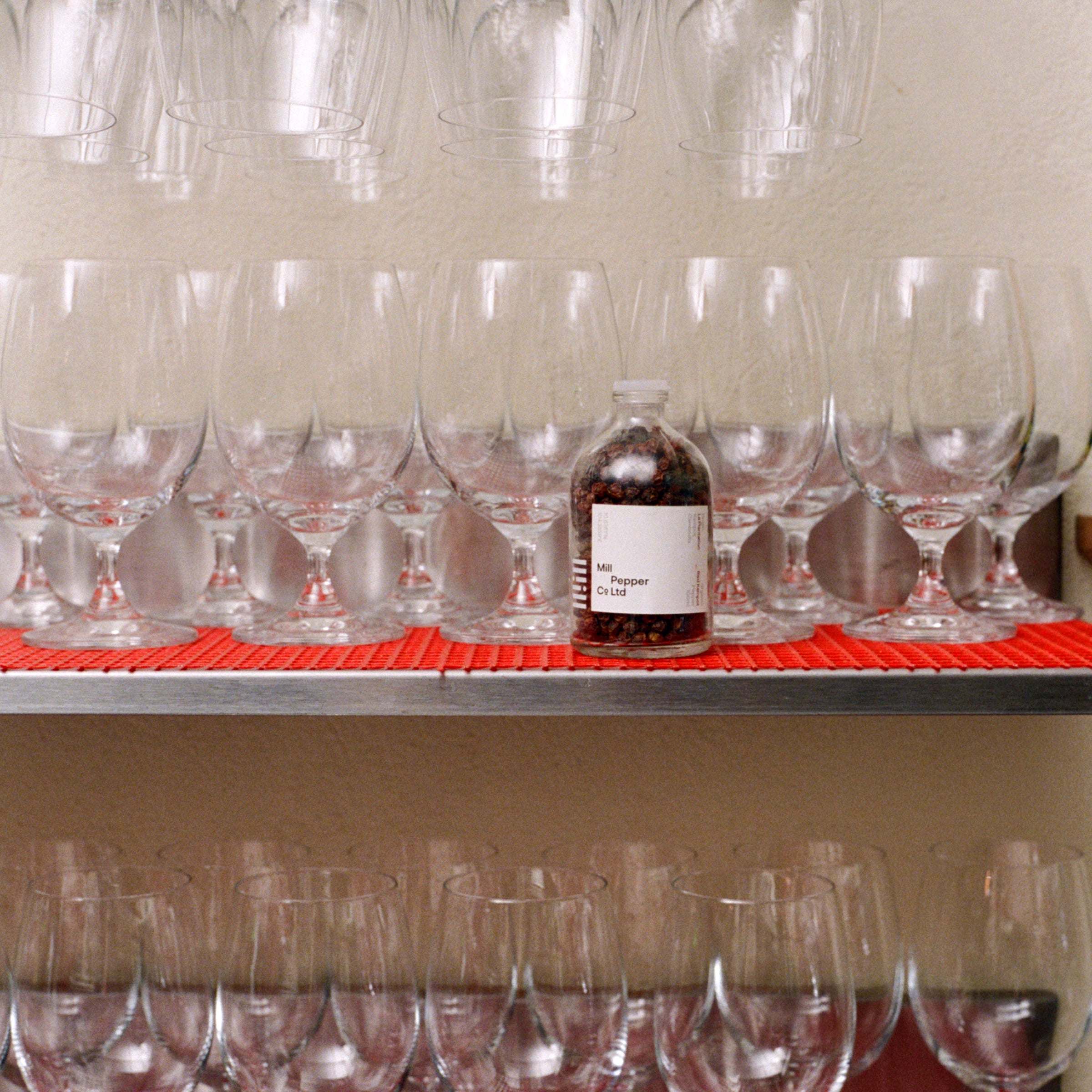 Mill Pepper shot in kitchen behind wine glasses.
